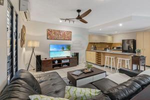 ein Wohnzimmer mit Couch und Küche in der Unterkunft Zen Serene Seascape - Family Pool - BBQ - Markets in Fannie Bay