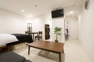 那覇市にあるプロスパービル 2Bの部屋にベッドとテーブルがある寝室
