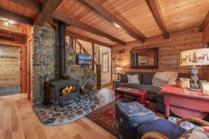 a living room with a fireplace in a log cabin at Cozy Pet-Friendly Cabin w Private Hot Tub Fenced In Yard Walk to HOA Beach & Pier in Homewood