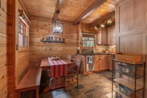 a kitchen with a table and a stove in a cabin at Cozy Pet-Friendly Cabin w Private Hot Tub Fenced In Yard Walk to HOA Beach & Pier in Homewood