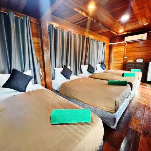 Maingern Maithong Resort في سارابوري: غرفة بثلاث اسرة عليها مخدات خضراء +82 صورة