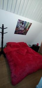 1 dormitorio con 1 cama roja con dosel en la pared en Finca buenos aires, en Manizales