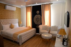 史卡杜的住宿－Kallisto Resort Skardu，一间卧室配有一张床、两把椅子和电视