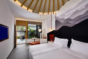 Cette chambre comprend 2 lits et une télévision. dans l'établissement Jinshanling Great Wall Hotel, à Chengde