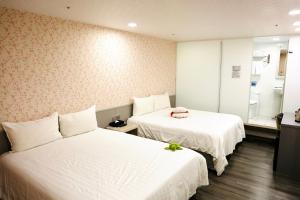 a hotel room with two beds and a mirror at 歐法行旅 O Fun Hotel in Taipei