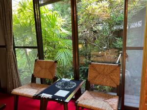 a table and two chairs on a screened in porch at Kappo Ryokan Uoichi in Shimada