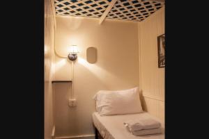 Piccola camera con letto e luce sul muro. di The Nolita Express Hostel a New York