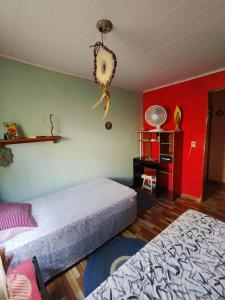 1 Schlafzimmer mit 2 Betten und einer roten Wand in der Unterkunft BiaMar in Luminárias