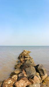 a pile of rocks in the middle of the water at Villa Gardenia Pantai Jepara in Jepara