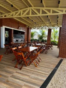 - un ensemble de tables et de chaises en bois sur une terrasse dans l'établissement Bee Cool Hostel, à Palmas