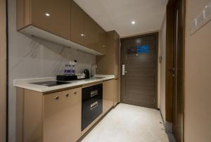 a small kitchen with a sink and a door at Zun Xiang Executive Apartment - Shenzhen Futian Exhibition Center in Shenzhen