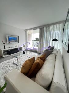 een woonkamer met een witte bank met kussens bij YOO Punta Del Este, innovador in Punta del Este