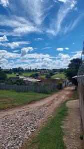 eine unbefestigte Straße mit einem Zaun und einem Feld in der Unterkunft BiaMar in Luminárias