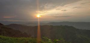 a view of the sun setting over the mountains at Finca buenos aires in Manizales