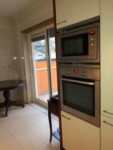 a microwave sitting on top of a stove in a kitchen at Apartamento Lisboa in Lisbon