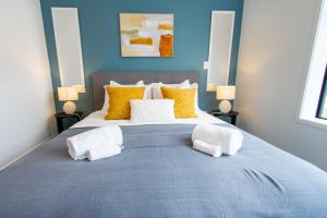a bedroom with a large bed with two towels on it at Glamorous 2 bed CBD townhouse w/King bed in Christchurch