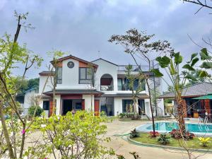 a house with a pool in front of it at AKIRA VILLA _ Venuestay in Ba Vì