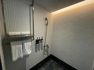 a bathroom with a shower with white towels at Hayata Hotel in Hengchun