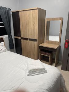 ein Schlafzimmer mit einem Bett mit einem Spiegel und einer Kommode in der Unterkunft S & K surin 