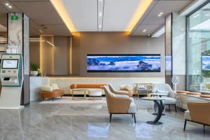 una sala de espera con sillas y una pantalla grande en Sochi Smart Resort Zhangjiajie en Zhangjiajie