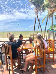 eine Gruppe von Menschen, die an einem Tisch am Strand sitzen in der Unterkunft Ikarus kiteboarding in Isla Mujeres