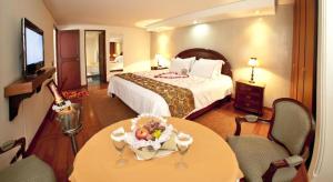 a hotel room with a bed and a table and chairs at Centro Internacional Apartahotel in Bogotá