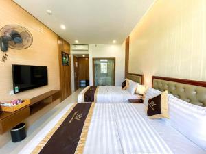 Habitación de hotel con 2 camas y TV de pantalla plana. en An Hotel Ha Long en Ha Long
