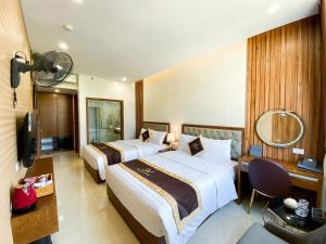 um quarto de hotel com duas camas e uma televisão em An Hotel Ha Long em Ha Long