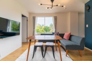 uma sala de estar com uma mesa e um sofá em Flower Base Lily House em Fukuoka