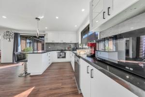 a kitchen with white cabinets and a counter top at Melbourne Airport Pet friendly Guest House in Melbourne