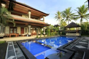 a villa with a swimming pool in front of a house at Villa Agung Khalia Ubud in Ubud