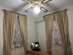 a living room with curtains and a ceiling fan at A peaceful room in Northbridge with free parking in Perth