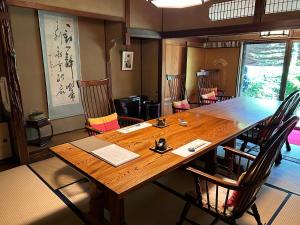 Kappo Ryokan Uoichi في Shimada: غرفة طعام مع طاولة وكراسي خشبية