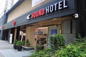 光州HOUND Hotel Sangmu的建筑物正面的受伤酒店标志