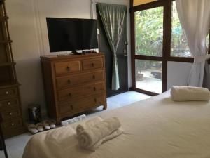 1 dormitorio con 1 cama con TV y vestidor en Many Trees, en Bangkok