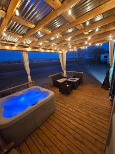 a large deck with a hot tub and a table and chairs at Matchbox desert oasis hot tub, pet friendly! in Las Cruces