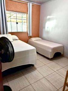 two beds in a room with a window at Recanto da Chapada in Alto Paraíso de Goiás