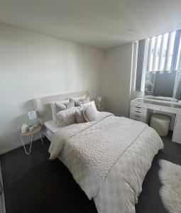Habitación blanca con cama y TV en Drummoyne Apartment, en Sídney