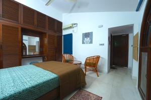 a bedroom with a bed and two chairs at House of Stories - Indiranagar, Bangalore in Bengaluru +62 photos
