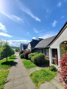 una casa blanca con una acera y arbustos en Charming English Tudor Lake union Seattle UW downtown en Seattle