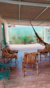 a patio with chairs and a hammock in a room at Recanto da Chapada in Alto Paraíso de Goiás