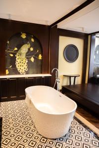 Legacy Hill Resort & Villas في Hòa Bình: حمام مع حوض استحمام على أرضية من البلاط
