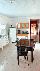 een keuken met een tafel en stoelen en een koelkast bij Recanto da Chapada in Alto Paraíso de Goiás