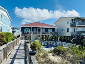 a house on the beach with a boardwalk at Sea Biscuit in Holden Beach