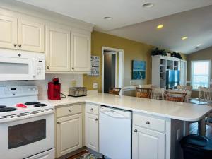 a kitchen with white cabinets and a counter top at Sea Biscuit in Holden Beach