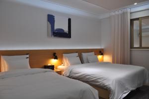 光州HOUND Hotel Sangmu的有两张床和一扇窗户的酒店房间