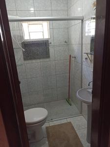 a bathroom with a shower with a toilet and a sink at Recanto da Chapada in Alto Paraíso de Goiás