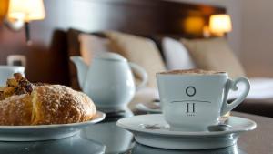 a cup of coffee and a pastry on a table at Hotel Orizzonte in Giugliano in Campania