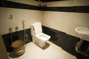 a bathroom with a toilet and a sink at Rasha residency in Kalpetta