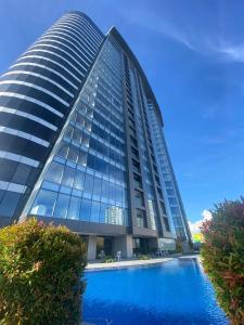 een hoog gebouw met een zwembad ervoor bij Aeon Towers Davao Condominium in Davao City